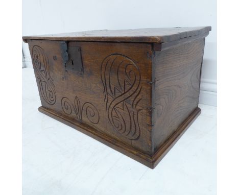 A late 17th/early 18th century elm chest; the figured top opening to reveal iron strap hinges and blacksmith made iron escutc