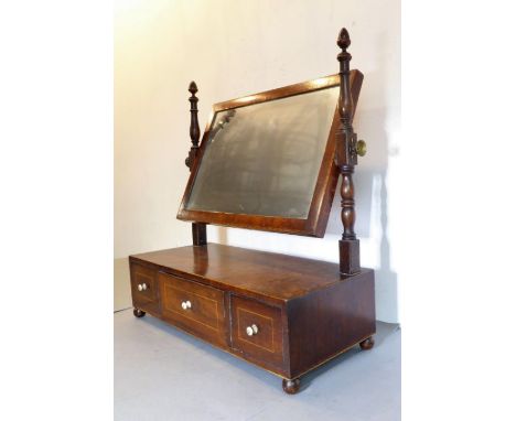An early 19th century mahogany and chequer strung toilet mirror; turned uprights and single central drawer flanked by two fur