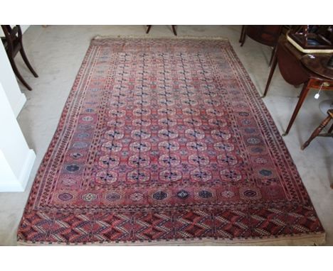 A TURKOMAN CARPET, having brick red ground with multi gull decoration, broadly framed and fringed, 208cm x 330cm 