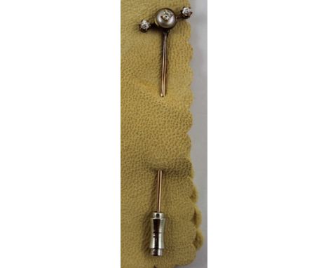 A DIAMOND THREE STONE SET STICK PIN having gold coloured metal mount and a base metal keeper 