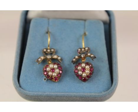 A PAIR OF VICTORIAN STYLE RUBY AND SEED PEARL HEART SHAPED DROP EARRINGS, each having a bow with diamond, on wire fitting 