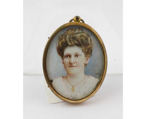 A MINIATURE PORTRAIT OF A LADY, watercolour on ivory, monogrammed FEL and dated (19)16 in oval brass ring mount frame 