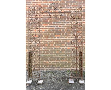 A large wrought iron archway, English or French, possibly 18th century, or later, the openwork frame with scrolls and petals 