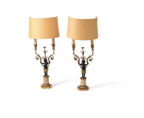 A pair of French patinated and parcel gilt metal and alabaster mounted figural candelabra, third quarter 19th century and lat