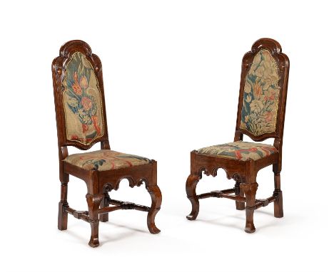 A pair of Queen Anne oak chairs, circa 1710, the backs and seats covered with floral tapestry, each 110cm high, 50cm wide, 46