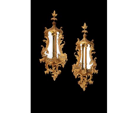 A pair of George III carved giltwood and gesso wall mirrors, late 18th/early 19th century, framed as stylised architectural r