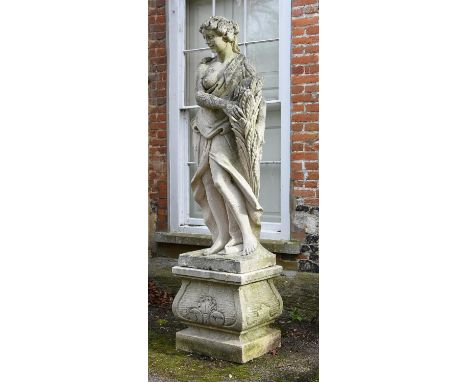 A large carved limestone model of Demeter or Autumn, 20th century, holding a sheaf of wheat against her partially draped body