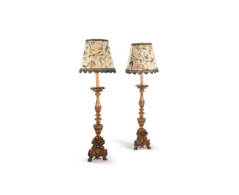 A companion pair of Italian giltwood altar sticks adapted as standard lamps, probably 18th century and later adapted, the cir