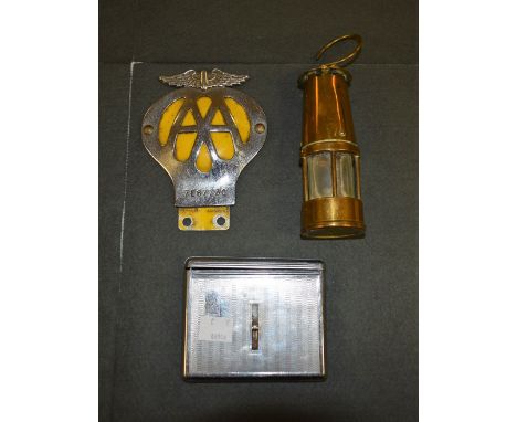 An unusual chrome cigarette case; an AA chrome badge and a brass miner's lamp 