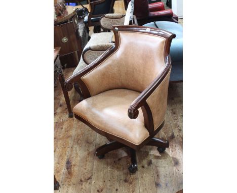 Mahogany framed and light brown leather swivel armchair.