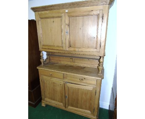 A 19th Century Continental Stripped and Waxed Pine Buffet, the upper section enclosed by a pair of panelled doors raised on t