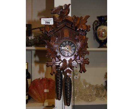 A Cuckoo Clock of Neat Proportions having hand carved decoration.