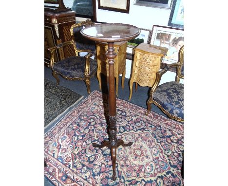 A Mahogany Torchere on a tripod base.