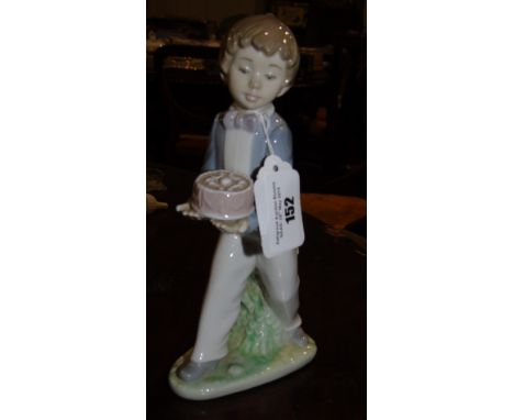 A Nao Figure of a Boy  holding a birthday cake along with another Figure of a Young Couple.