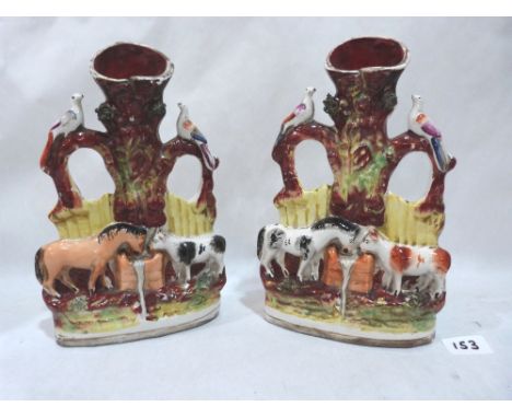 A pair of 19th century Staffordshire spill vases, moulded with a horse and cow drinking from a water trough. 10½' high