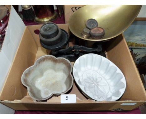 A set of weighing scales and two ceramic moulds