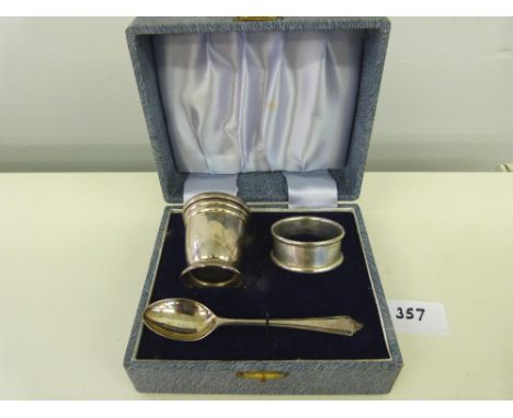 A silver three piece christening set comprising an eggcup, spoon and napkin ring. Various hallmarks. 1oz 8dwts