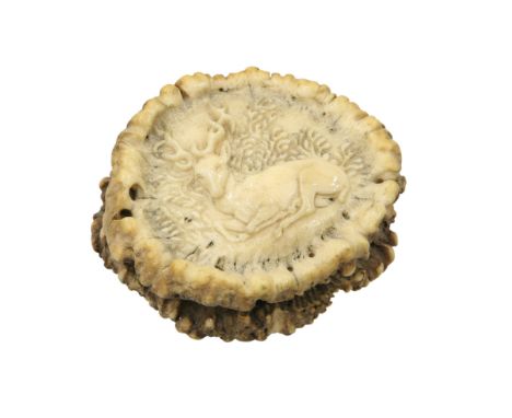 A 19TH CENTURY STAG ANTLER SNUFF BOX, the cover carved with a recumbent stag, the base with turned ring. 7cm by 6cm