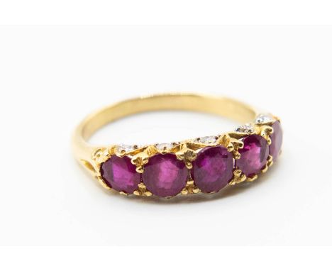 A LATE VICTORIAN RUBY SET RING, the five graduating rubies set in a pierced mount set throughout with ten brilliant cut diamo