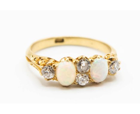 A LATE VICTORIAN OPAL AND DIAMOND RING, the two oval cut opals and four old cut diamond highlights set in a heavily moulded s