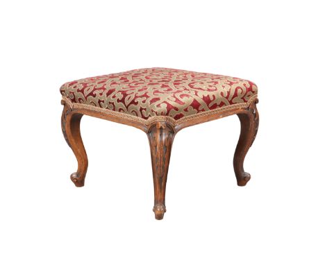 A VICTORIAN WALNUT AND UPHOLSTERED STOOL, the square upholstered seat raised on leaf carved cabriole legs terminating in scro