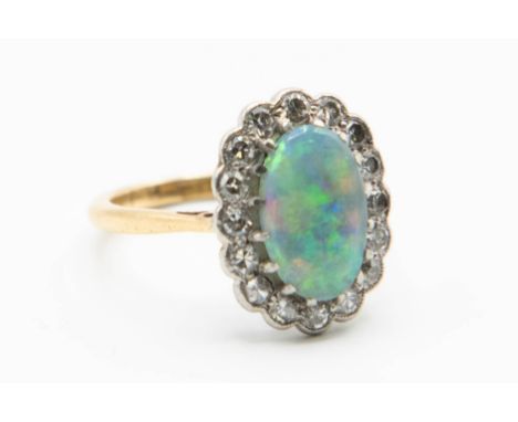 A LATE 19TH CENTURY 18CT YELLOW GOLD OPAL AND DIAMOND RING, the oval cut opal claw set within a surround of sixteen old brill