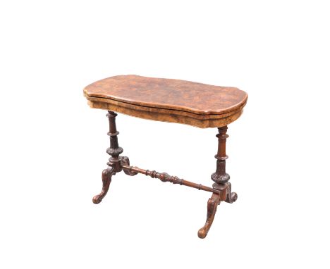 A VICTORIAN BURR WALNUT FOLDOVER CARD TABLE, the quarter veneered moulded top of serpentine outline, swivelling to reveal a b