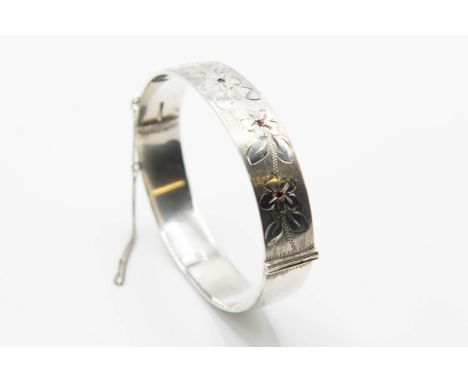 A SILVER BANGLE WITH GEORG JENSEN LTD SPONSORS MARKS, the hinged bangle with engraved floral design set with five round cut r