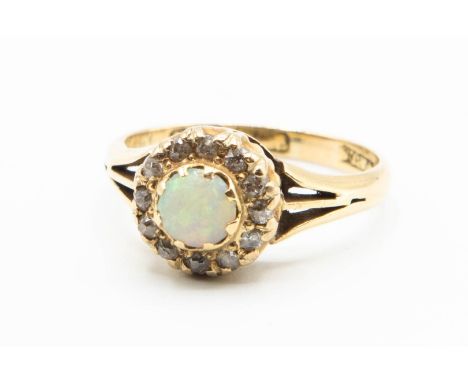 A VICTORIAN OPAL AND DIAMOND RING, the single round cabochon cut opal set within a surround of brilliant cut diamond highligh