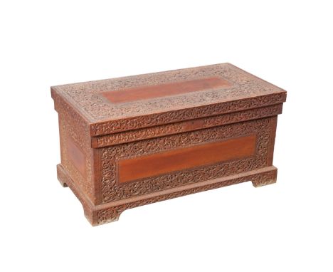 AN INDIAN CARVED TEAK TRUNK, 19TH CENTURY, rectangular, carved with scrolling foliage, raised on bracket feet. 50cm high, 101