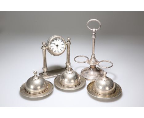 A GROUP OF SILVER-PLATE, comprising a Christofle oil and vinegar bottle stand, architectural clock and three covered butter d