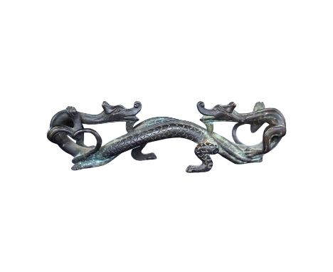 A Chinese bronze brush rest modelled as two dragons, 17cm wide. Condition - good