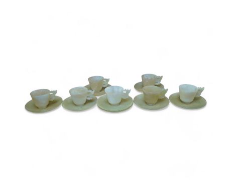 A set of seven Chinese bowenite jade cups and eight saucers, 11cm in diameter. Condition - fair to good