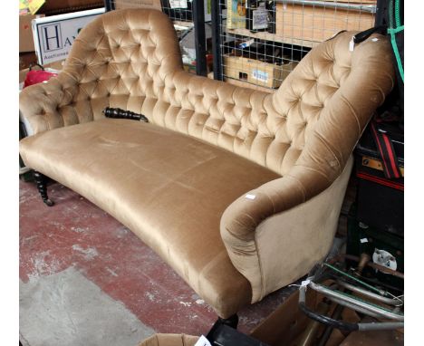 A mid Victorian deep button back settee, with a sprung upholstered seat, standing on turned legs.