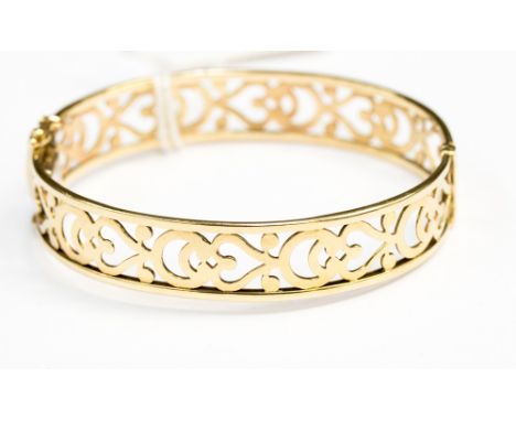 A 9ct gold hinged bangle with pierced heart decoration, 18.5 grams approx. 