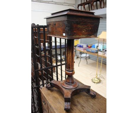 A George IV rosewood teapoy, the caddy section raised on an octagonal column, standing a platform base, with scrolled feet