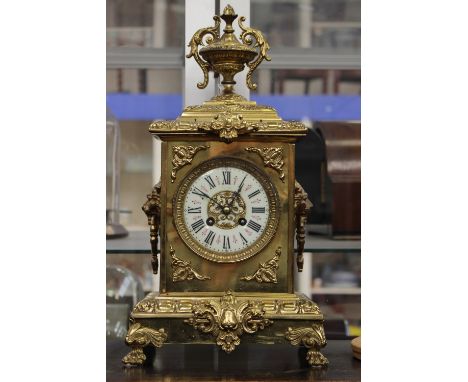 A late 19th Century French gilt and brass eight day mantle clock, the white enamel dial with black Roman numerals, complete w