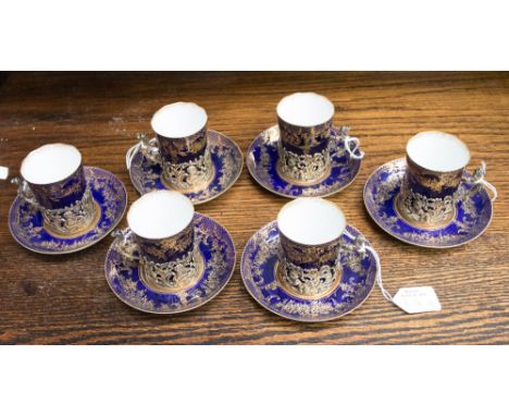 A set of six Staffordshire eggshell coffee cans and saucers, the cans fitted in silver cup holders of pierced foliate form, e