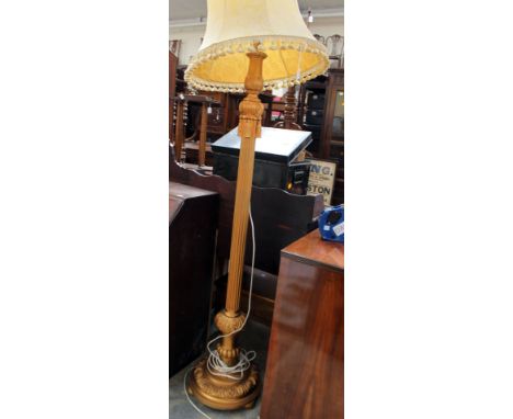 A contemporary Classical style gilt standard lamp, fitted with a cream shade