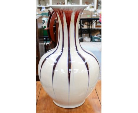 An oversize ceramic floor vase of baluster form, cream streaked with red glazes, height 86cm