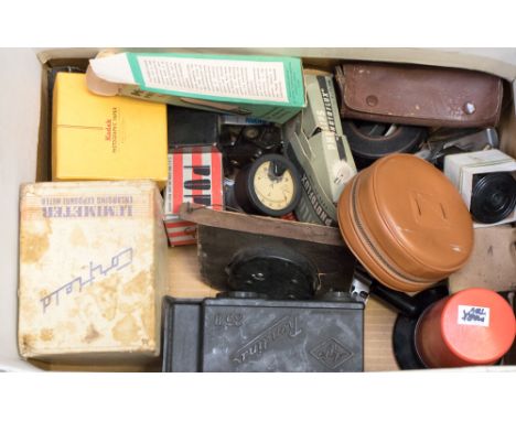 A box of camera accessories including a Patterson developing room lamp, an Agfa Rondinax 35U, along with a 1944 army aircraft