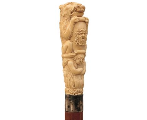 AN EDWARDIAN WALKING STICK, the large carved ivory handle in the form of a heraldic lion holding a shield decorated with the 