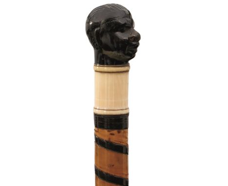 AN EARLY/MID 19TH CENTURY SWORD STICK, the pressed horn pommel in the form of an Afro-American gentleman's head, ivory collar