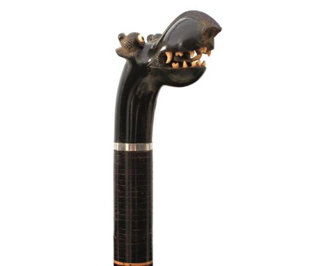 AN EARLY 20TH CENTURY INDIAN FLEXIBLE SECTIONAL WALKING STICK, the carved horn handle in the form of a stylized monster's hea