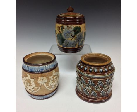 A Doulton Lambeth tobacco jar, applied with flowering sprigs on a sgraffito ground, surmounted by graduating, raised banding 