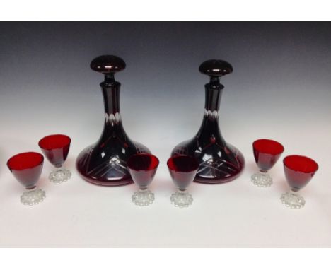 A pair of 20th century Bohemian ruby and clear cut glass ships decanters, mushroom stoppers;  six conical bowl ruby wine glas