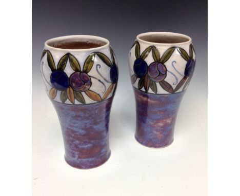 A pair of Royal Doulton inverted balusted stoneware vases, decorated with a wide collar of purple and blue flowers on a cream
