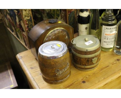 A walnut cased two hole mantel clock; and two oak biscuit barrels 