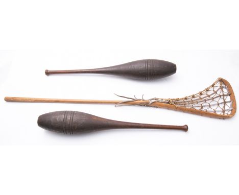 A pair of stained pitch pine Indian clubs, 67cm long and a beach lacrosse stick (3) 