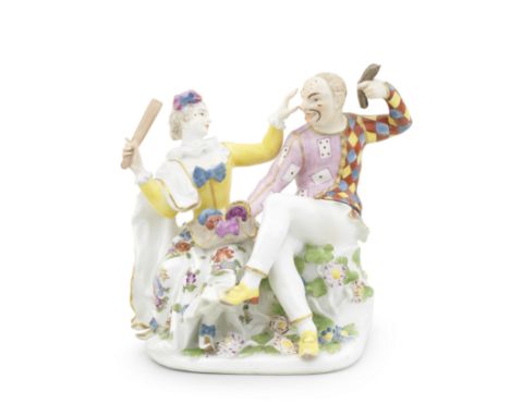 A Meissen group of Harlequin and Columbine, mid 18th centuryModelled by J.J. Kaendler, both seated, he wearing a mask, a tuni